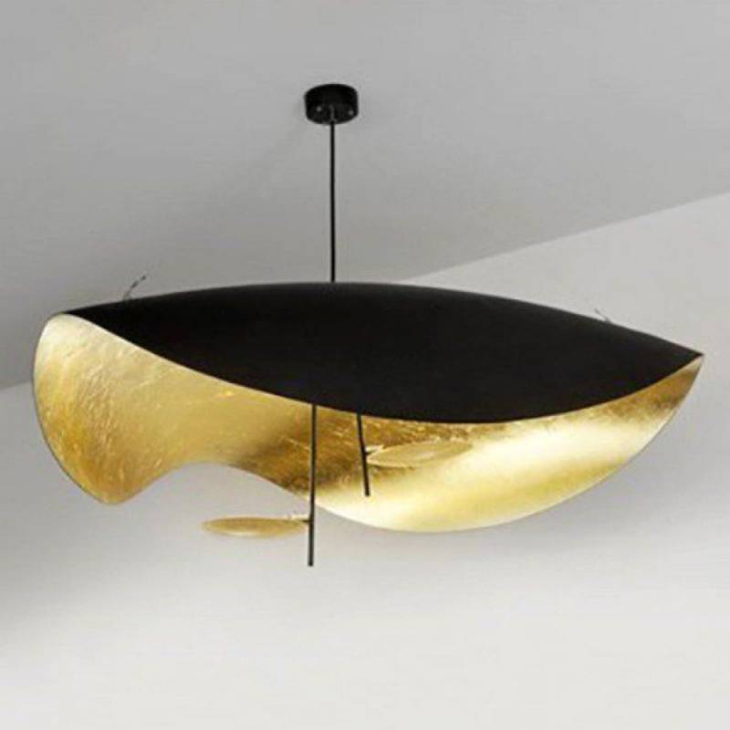 Lampada da soffitto nera e oro, appesa al soffitto. La parte inferiore è ricoperta di foglia d'oro.