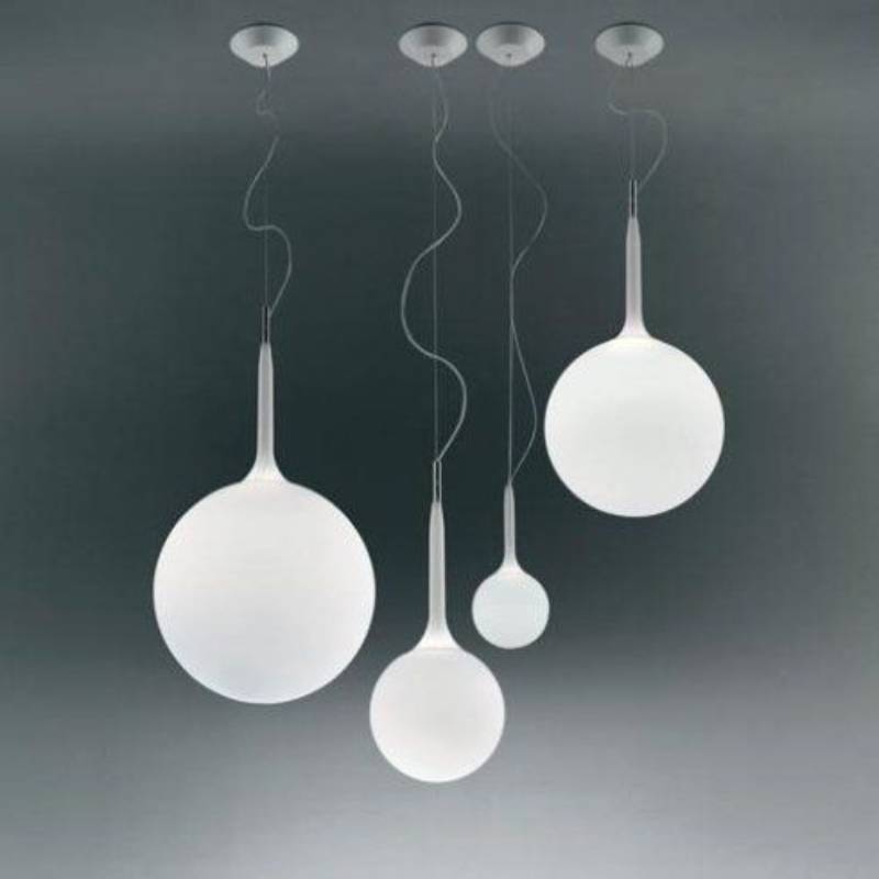 Quattro lampade a sospensione a forma di globo bianco, di dimensioni variabili, pendono dal soffitto.