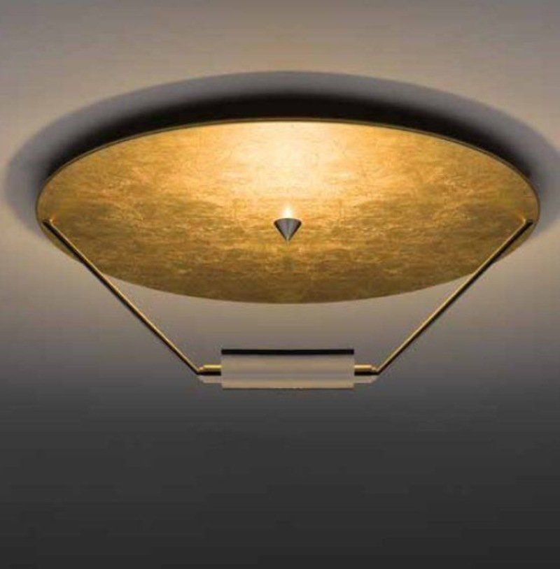 Lampada da soffitto color oro con cornice geometrica e dettaglio centrale, montata su un soffitto bianco.