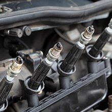 A close up of a car engine with spark plugs in it.