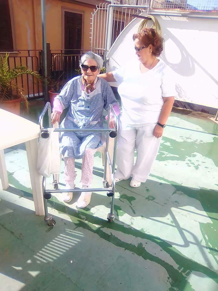 Donna anziana con deambulatore e assistente in casa di riposo