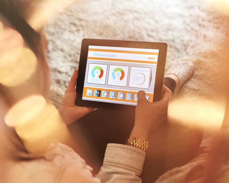 Female homeowner checking energy consumption on digital tablet using smart meter technology.
