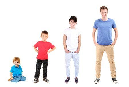 A group of young boys of various ages are standing next to each other in a row.