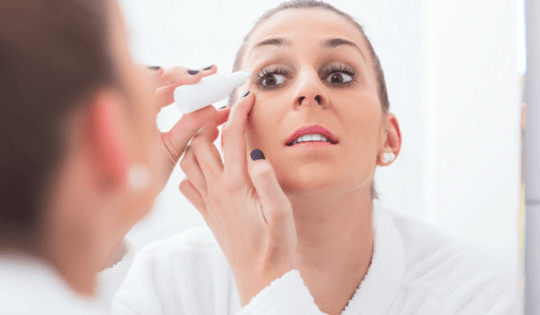 woman with dry eyes using lubricating tears.