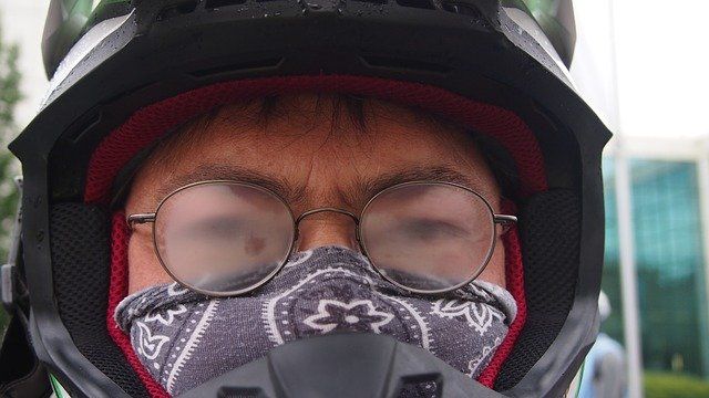 Person with a face mask and foggy glasses