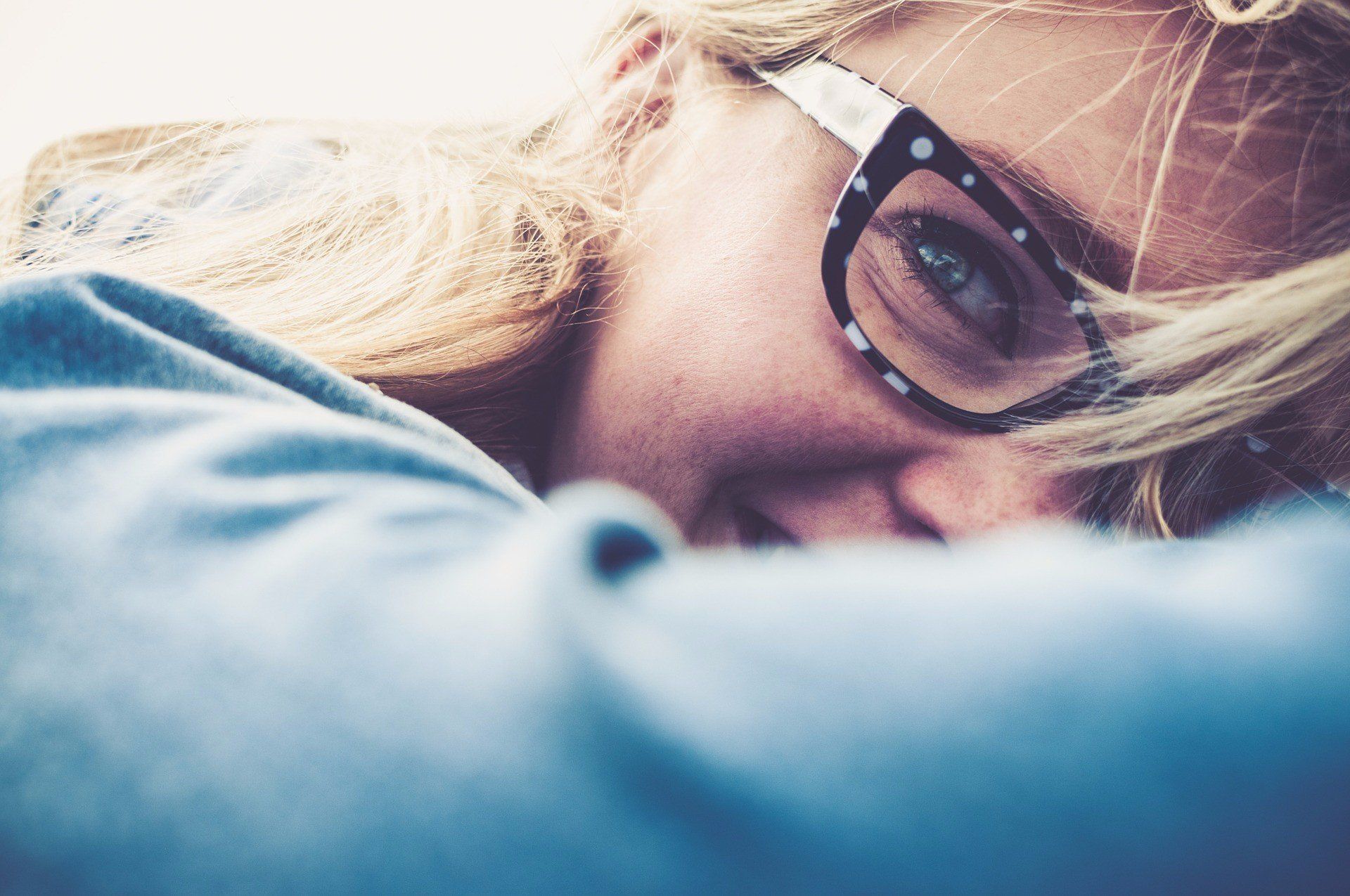 close up of blonde woman wearing a polka dot eyeglass frame