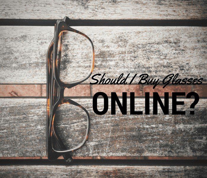A pair of glasses on a wooden table with the words should i buy glasses online