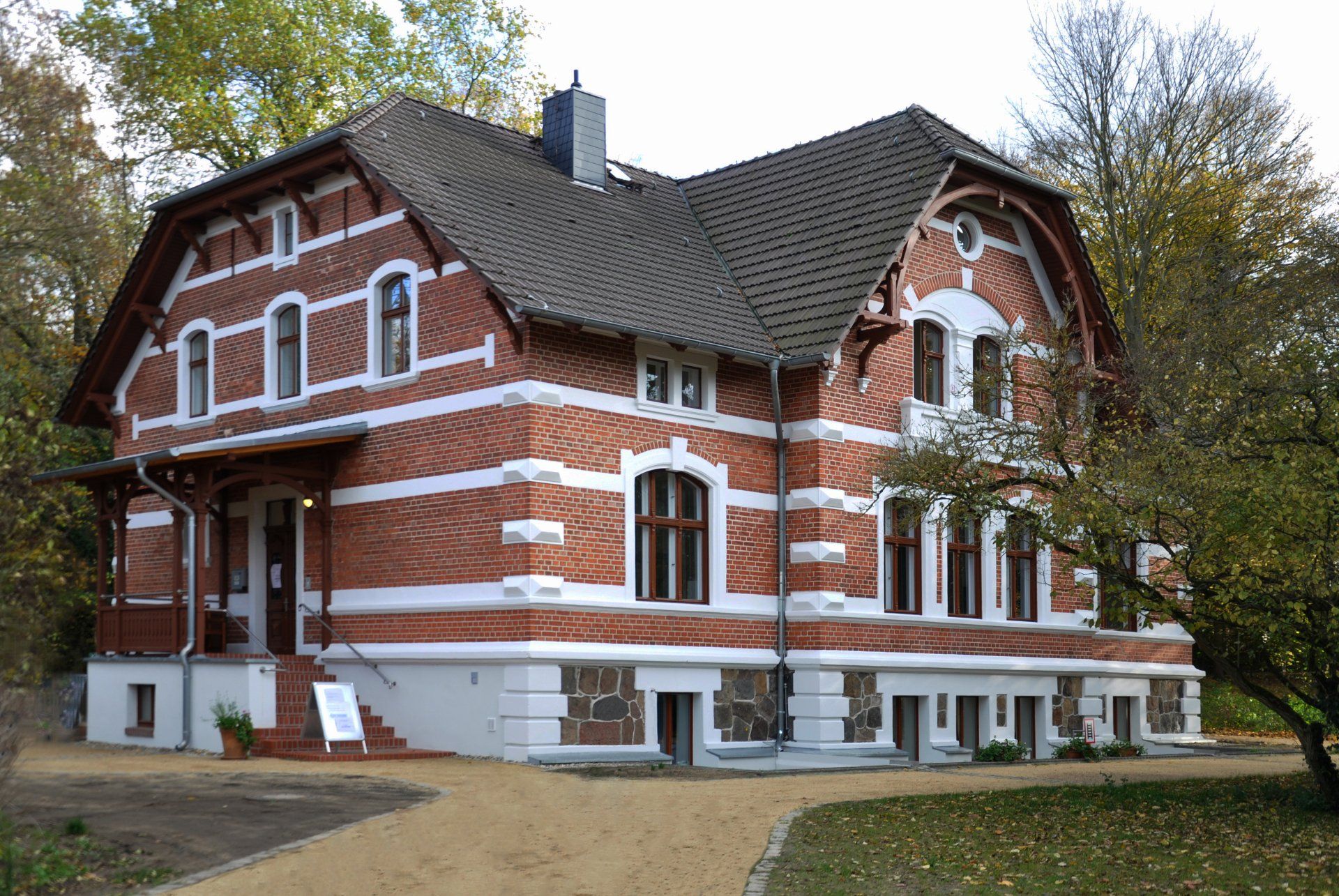 A large red and white brick house with a brown roof