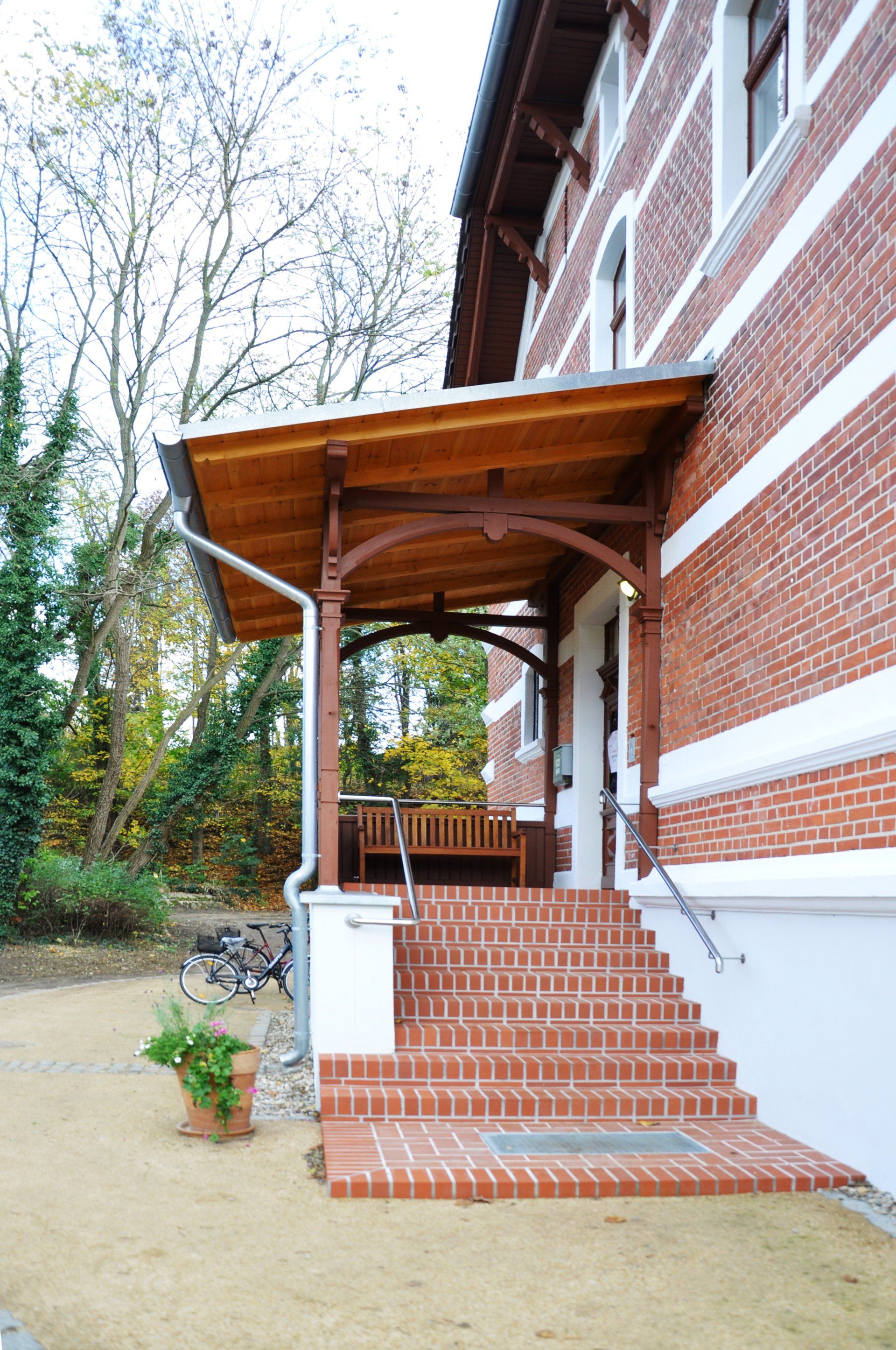 A brick building with a wooden porch and stairs