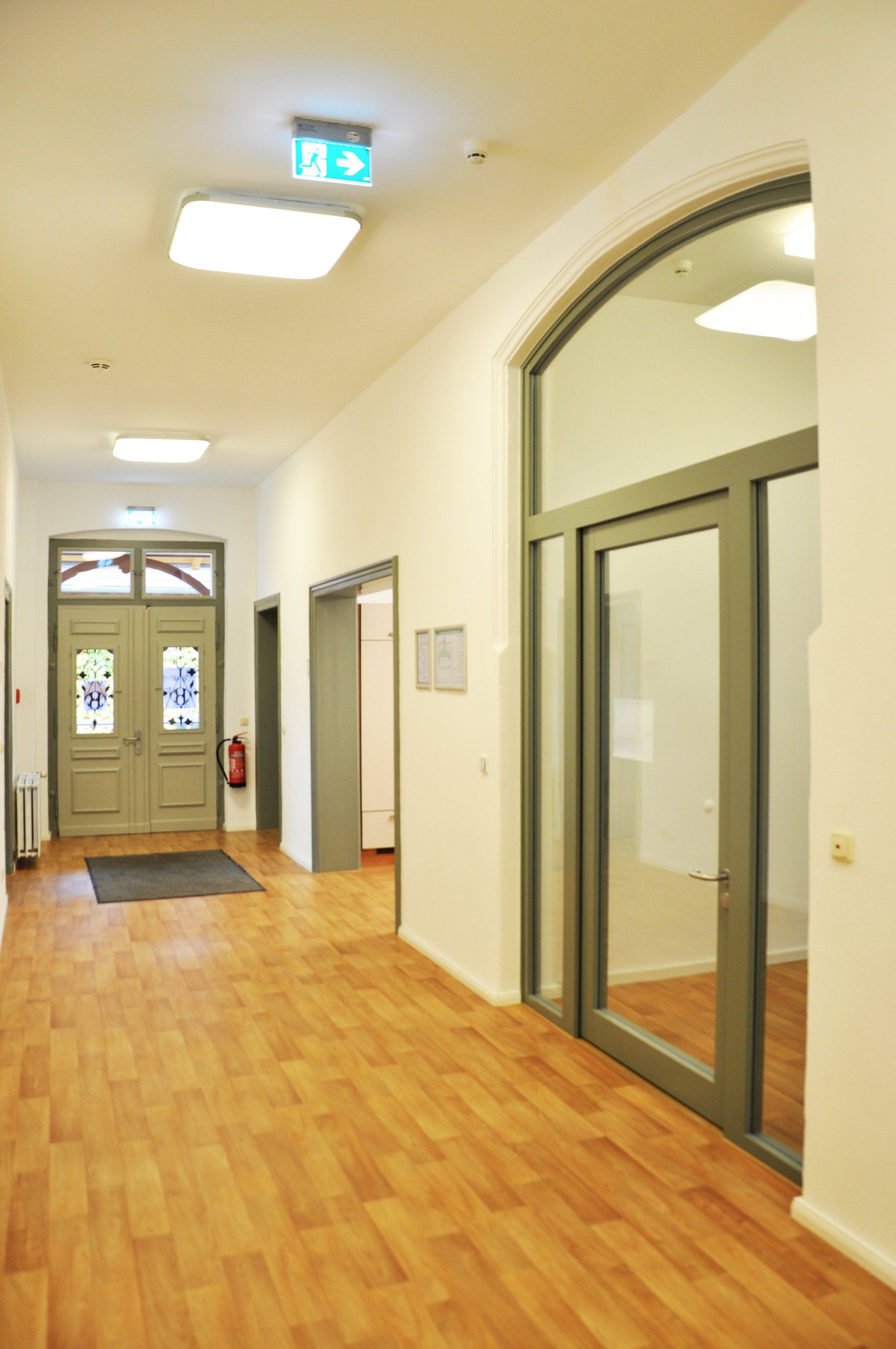 A long hallway with wooden floors and sliding glass doors