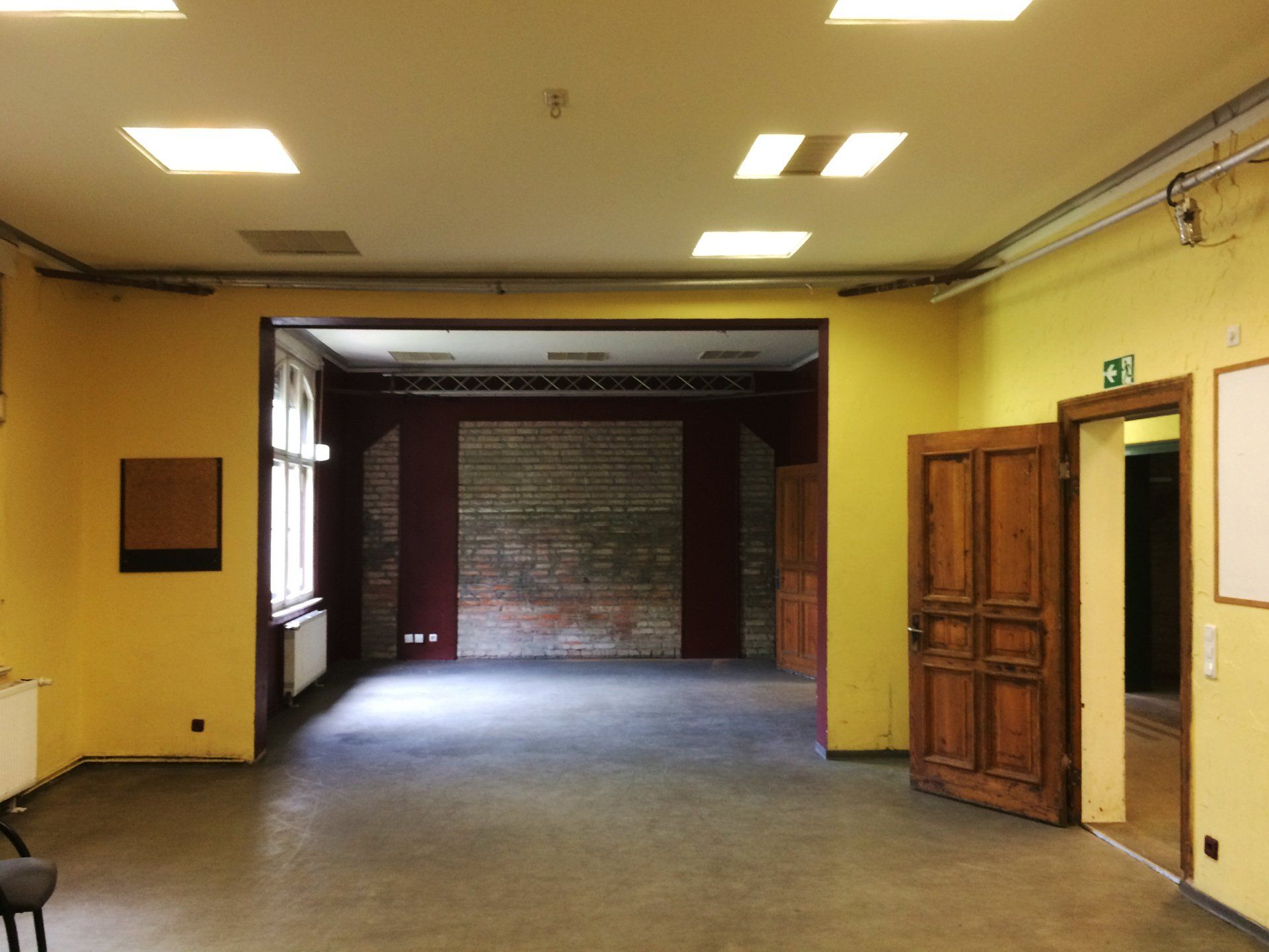 An empty room with yellow walls and wooden doors