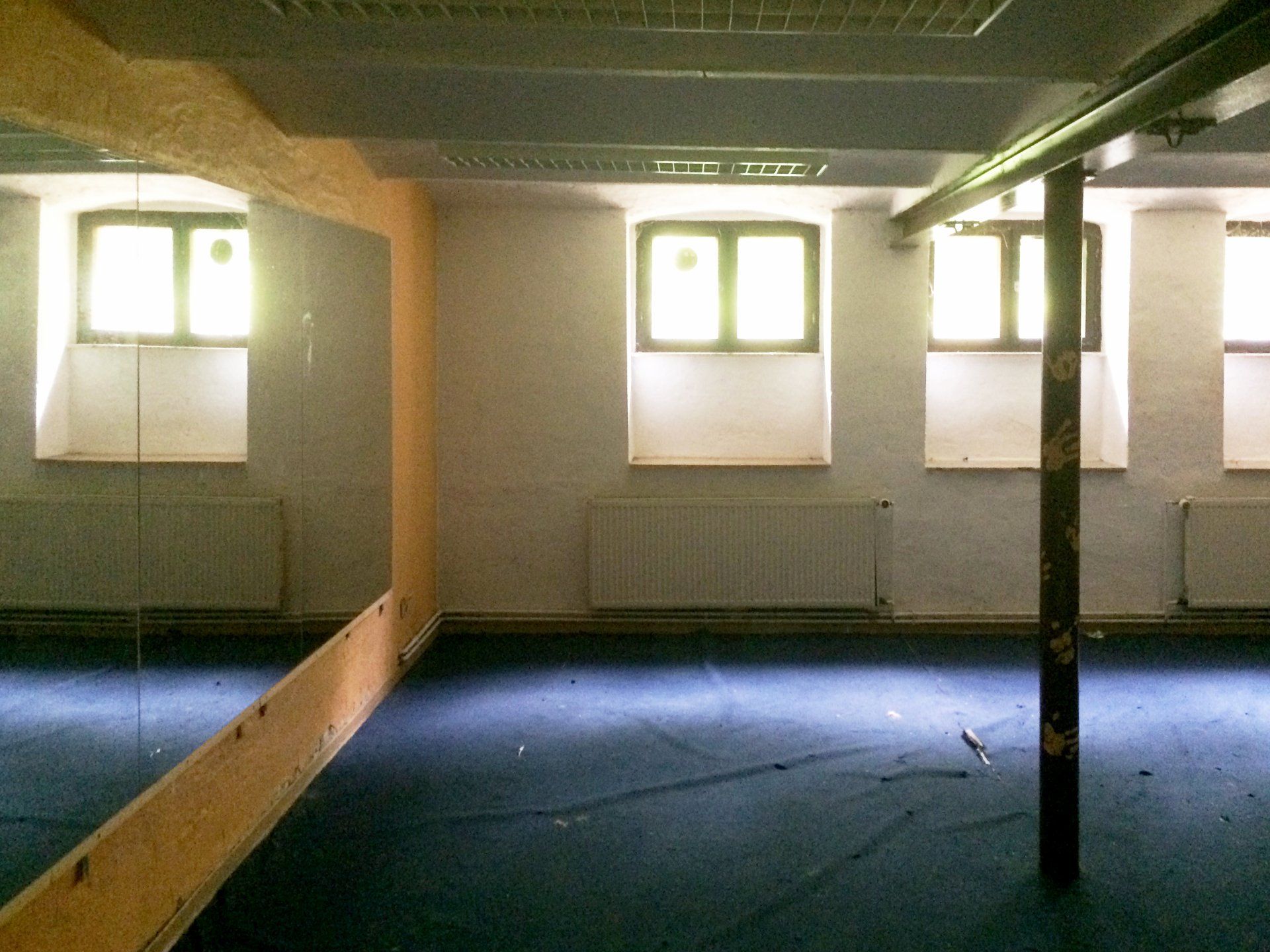 An empty room with a mirror on the wall