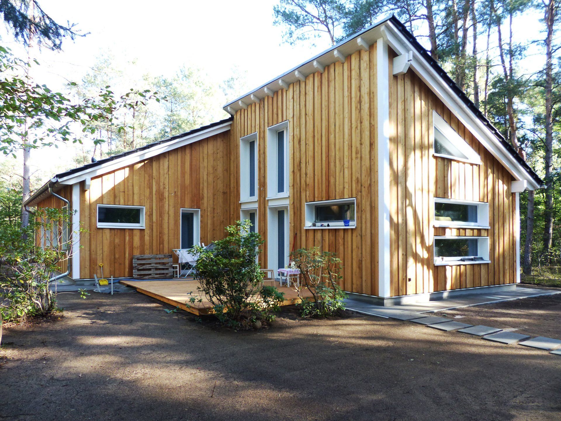 A house with a lot of windows is surrounded by trees