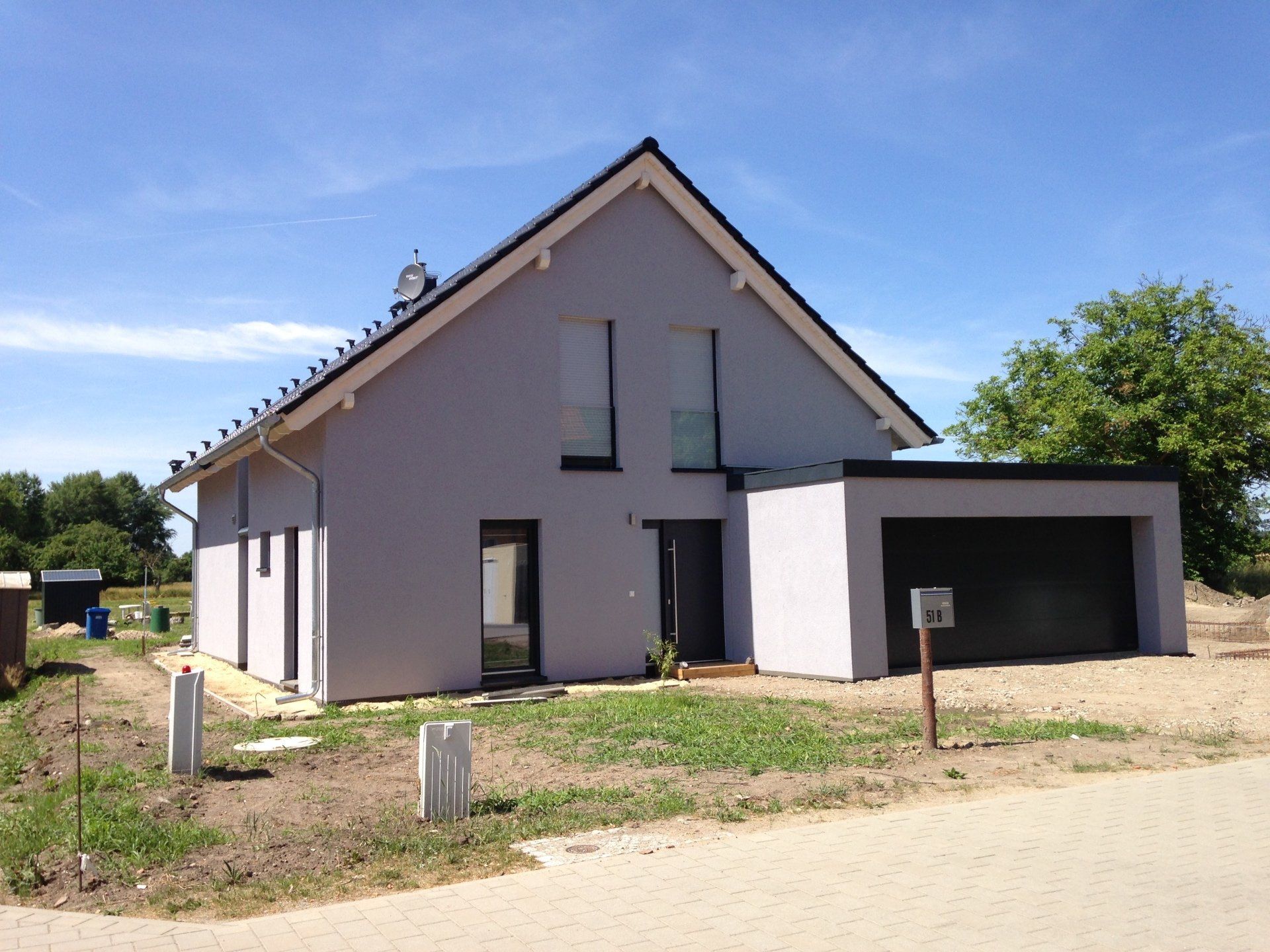 A house with a garage and a blue sky in the background