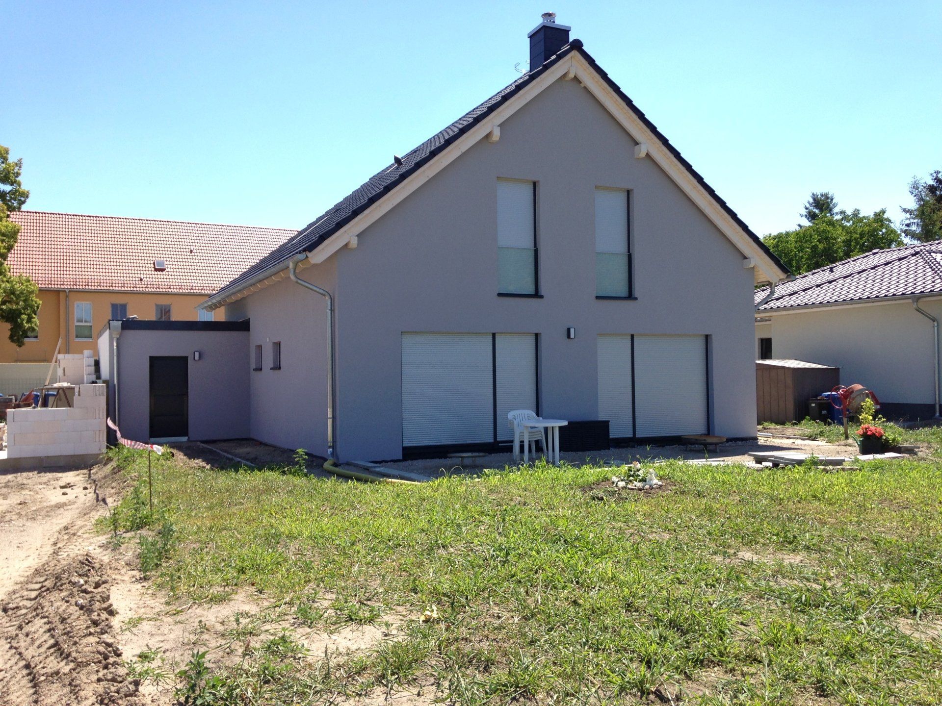 A house with a lot of windows and a table in front of it