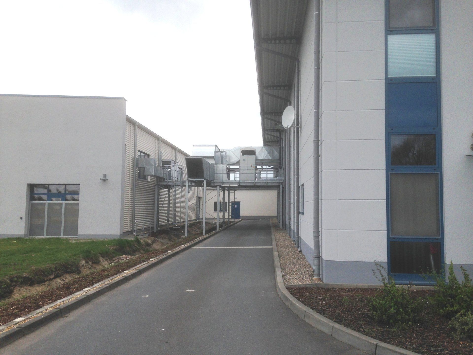 A white building with blue windows is next to another building