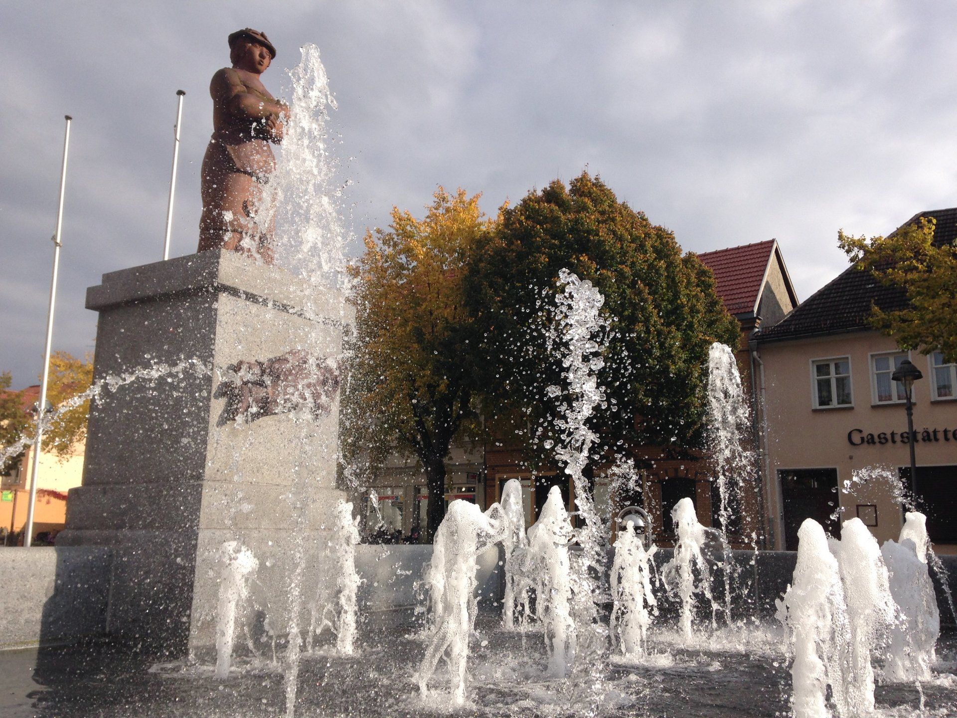 A fountain in front of a building that says gasthaus