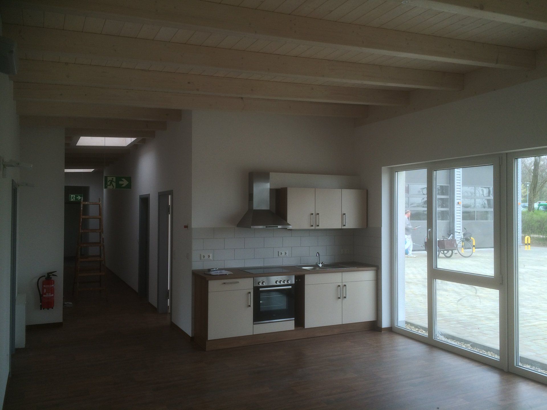 An empty kitchen with a fire extinguisher on the wall