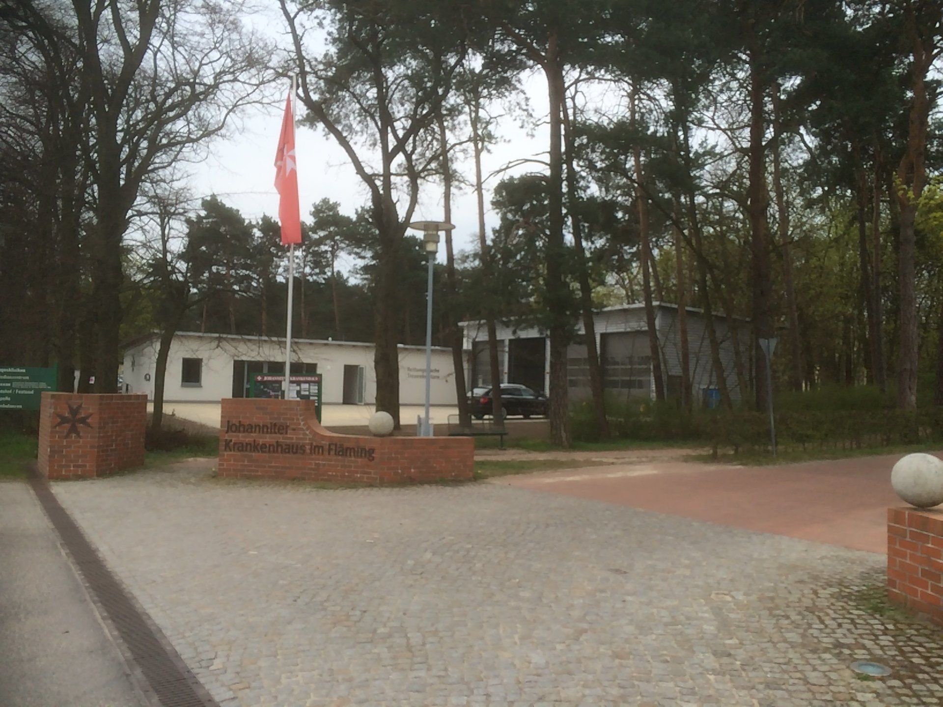 A red flag is flying in front of a building