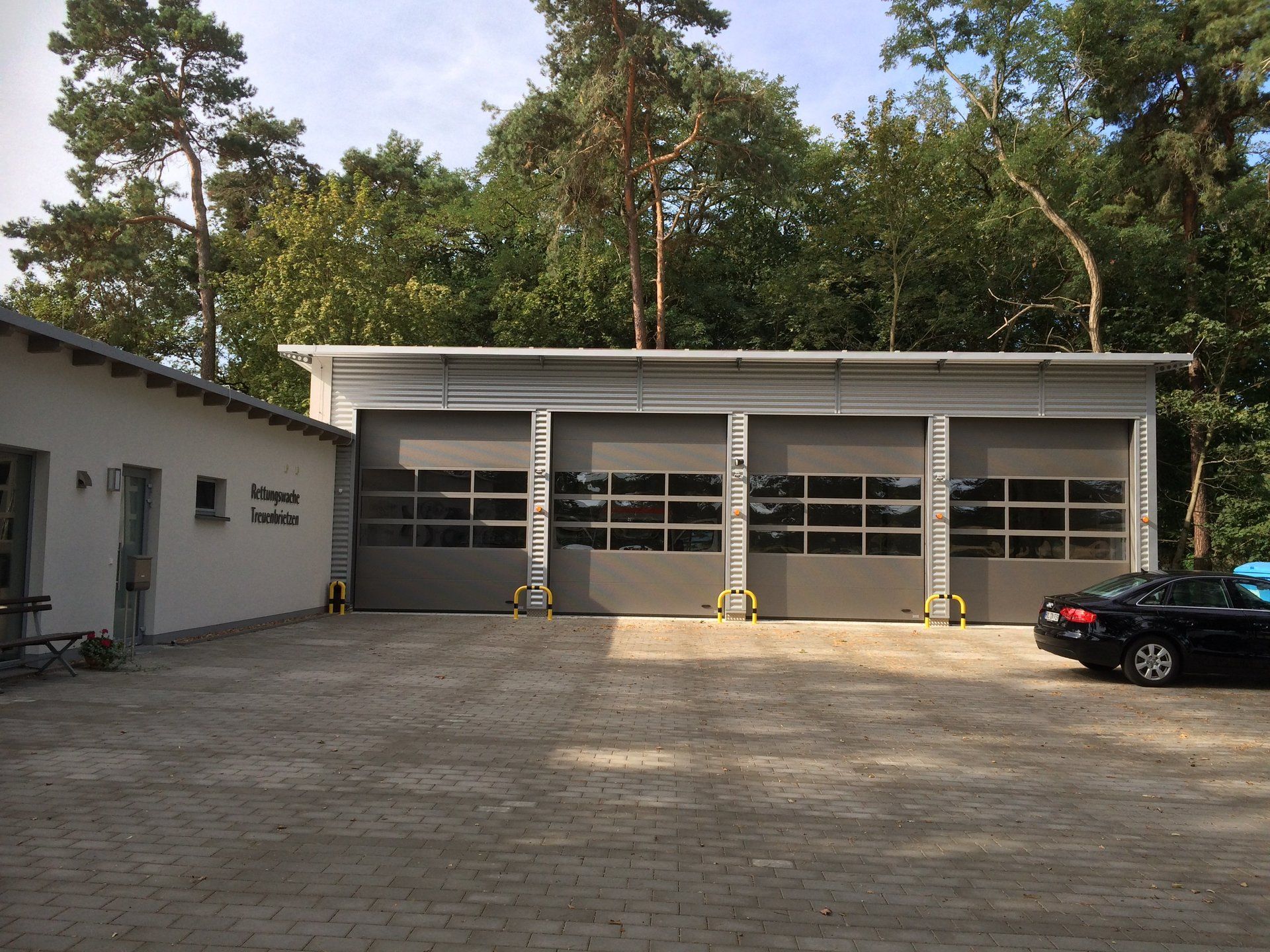 A black car is parked in front of a garage door