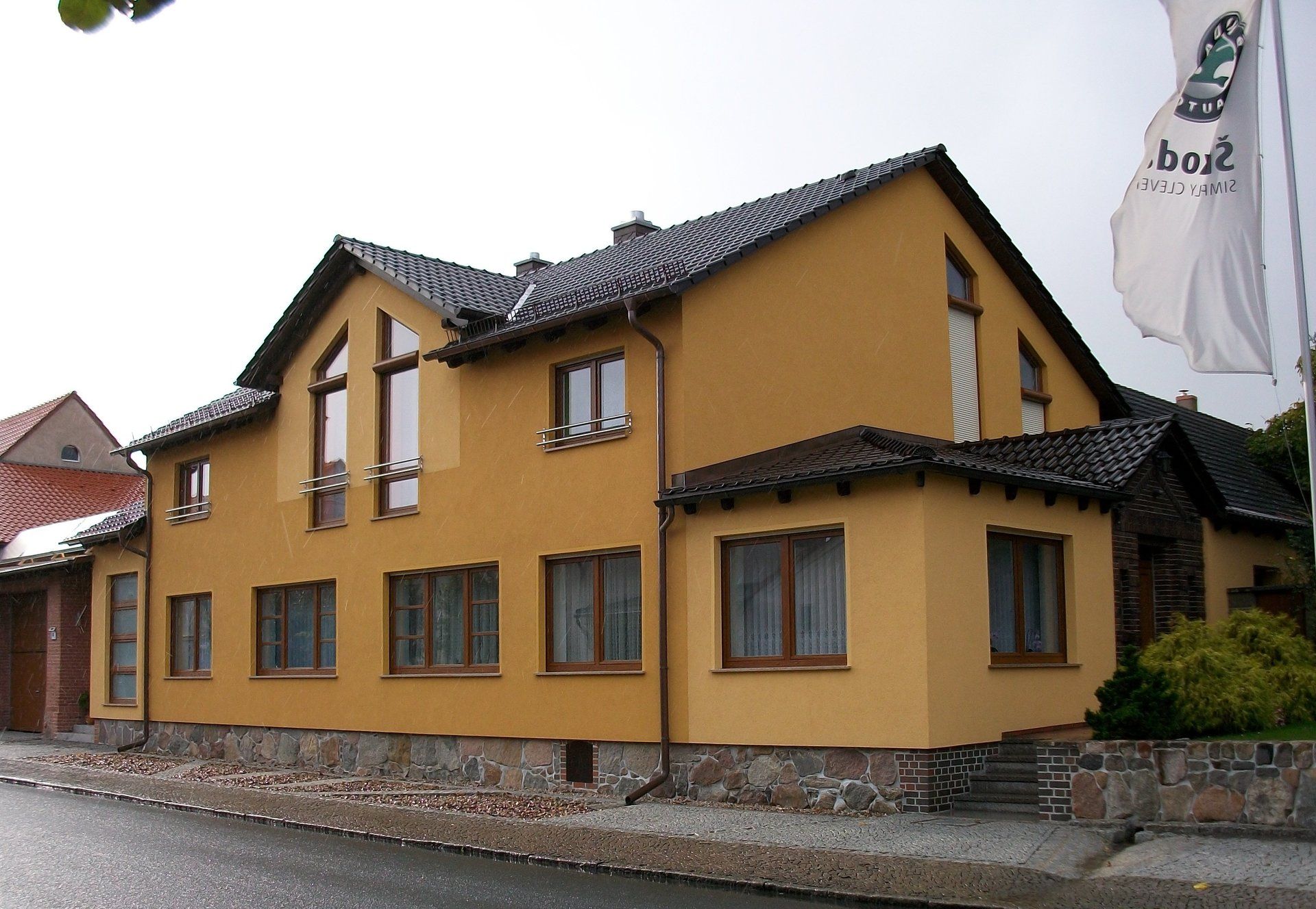 A yellow house with a flag that says burg on it