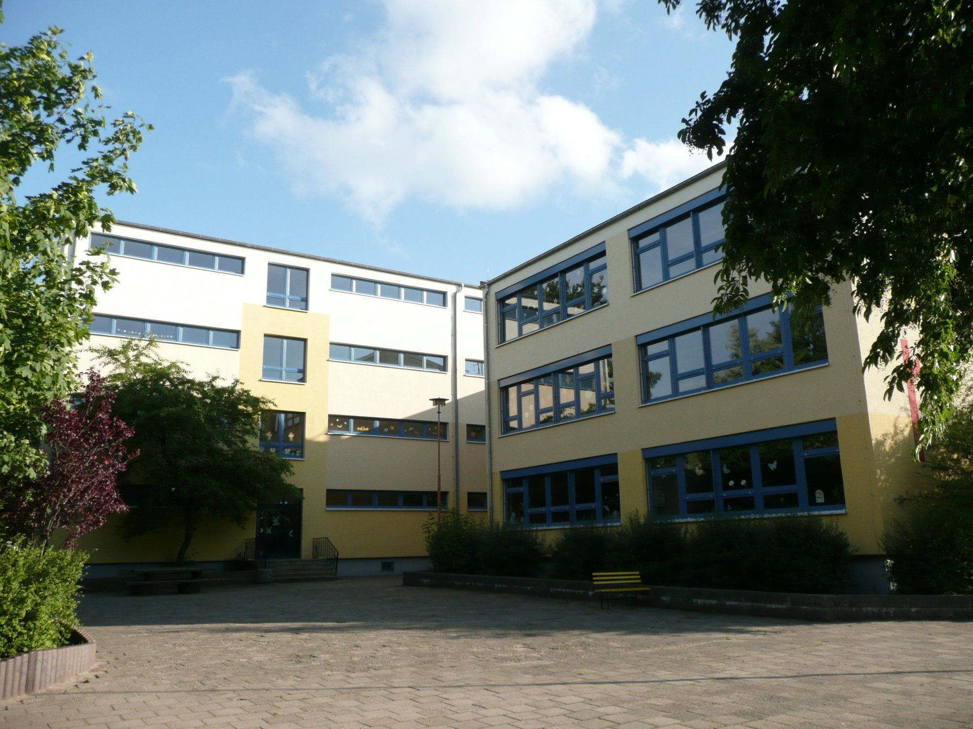 A large building with lots of windows and trees in front of it