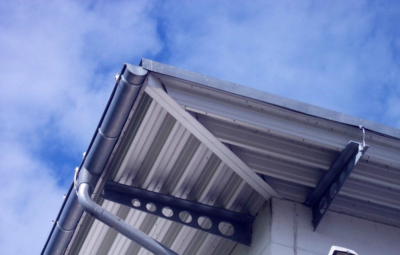 Looking up at the roof of a building with a blue sky in the background