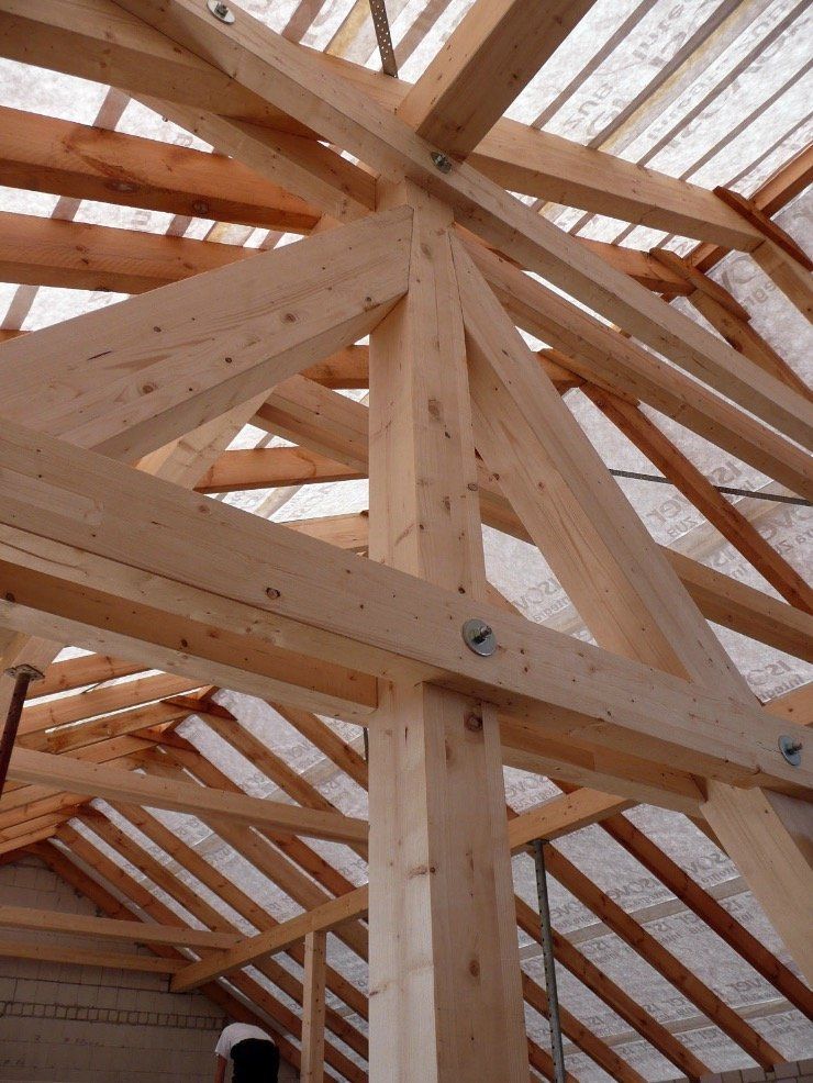 The roof of a building is being built with wooden beams