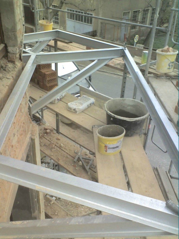 A metal frame is sitting on top of a wooden scaffolding.