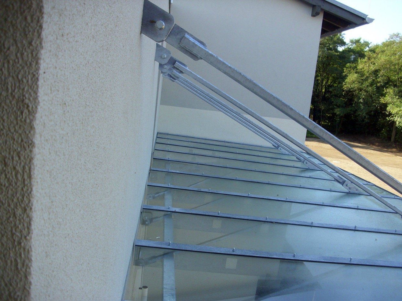 A white building with a glass roof and a metal railing