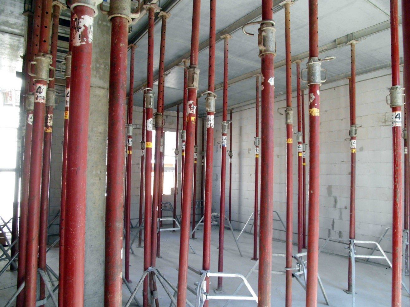 A bunch of red poles are lined up in a room
