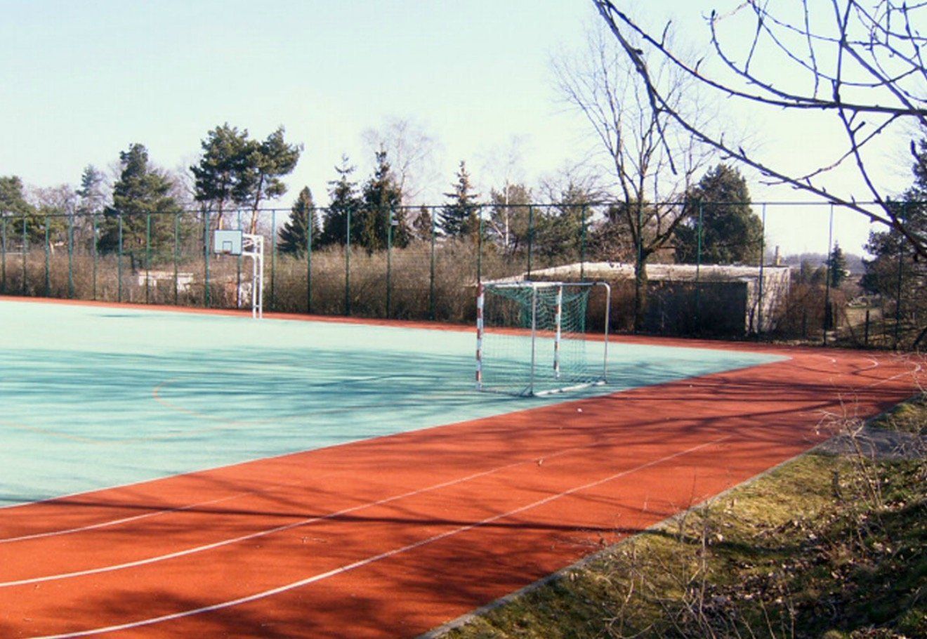 A soccer field with a goal and a basketball hoop