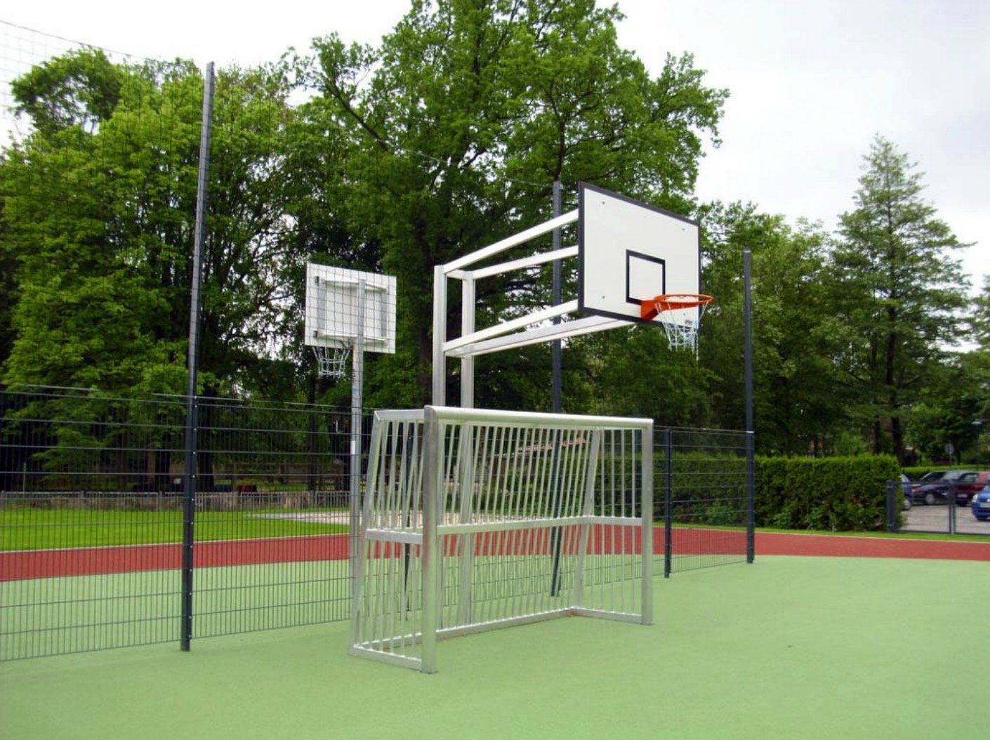 A basketball hoop is sitting on top of a soccer goal.