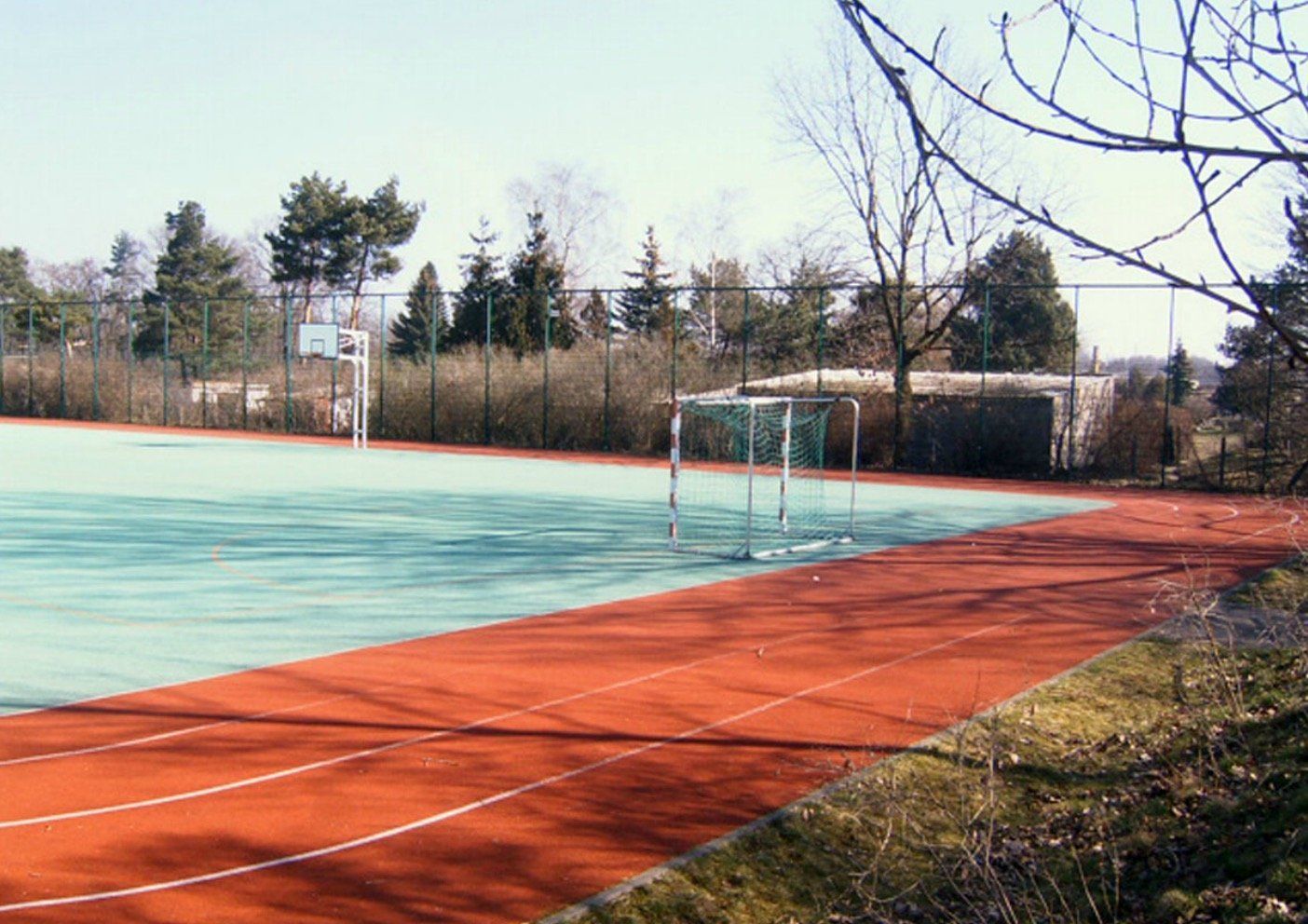 A soccer field with a goal and a basketball hoop