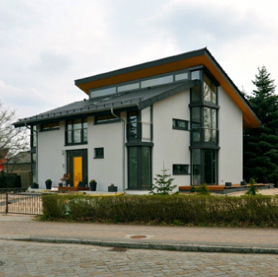 A white house with a black roof and a yellow door