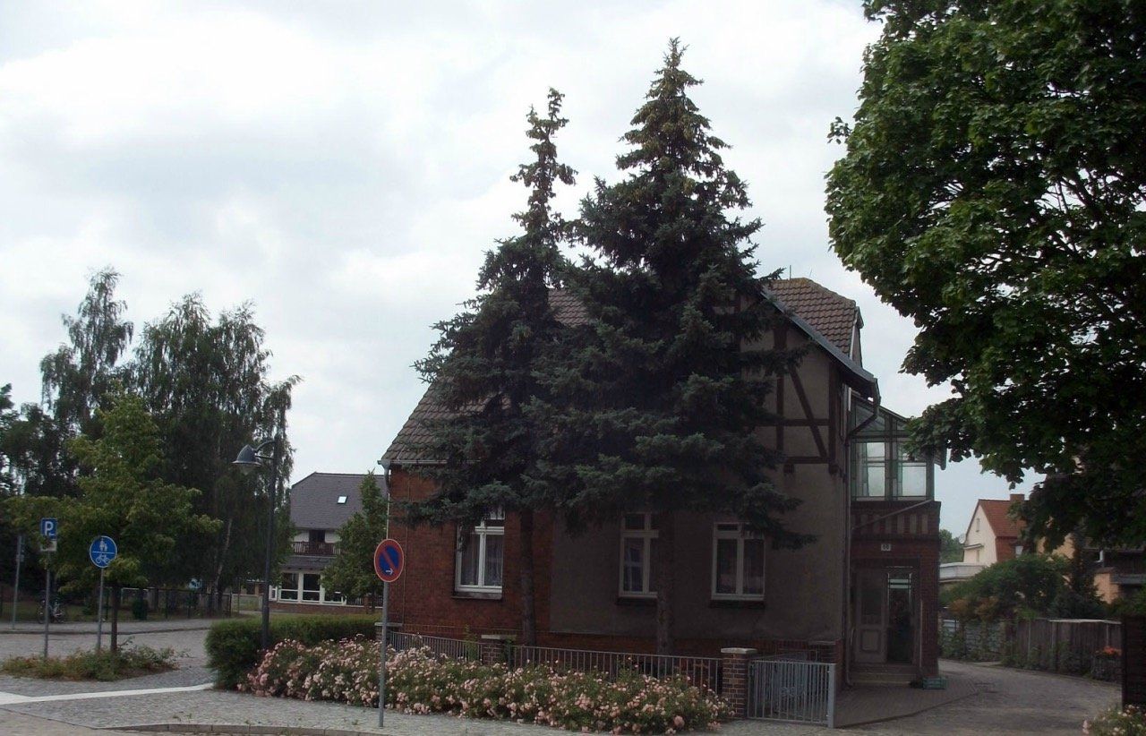 A brick house with a tree in front of it