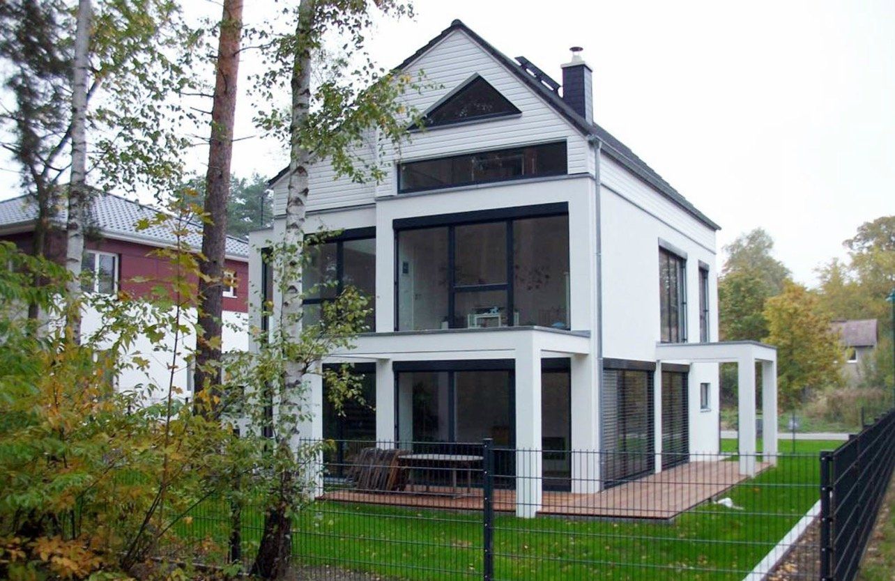 A large white house with a fence in front of it