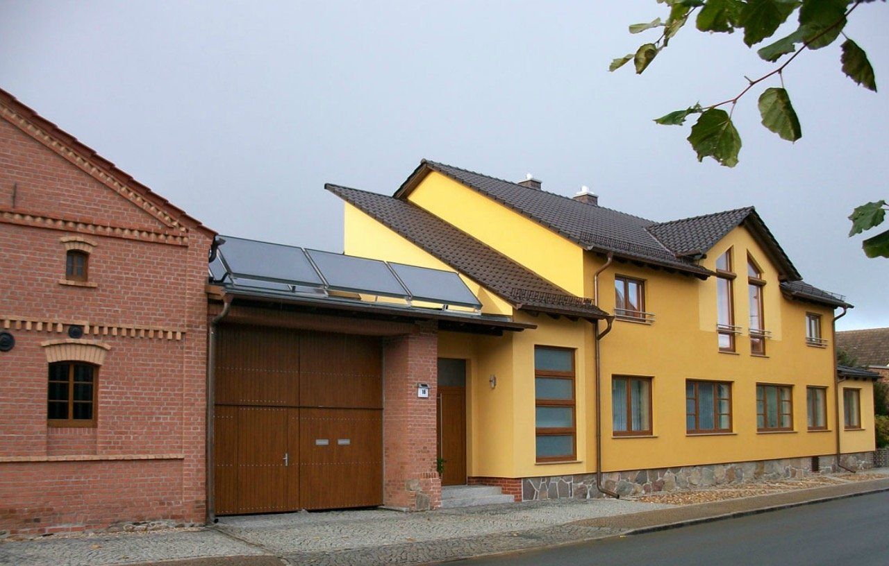 A yellow house is next to a red brick building