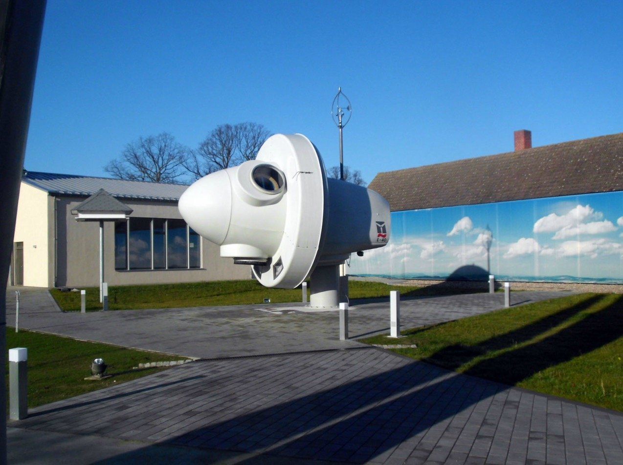A large white object in front of a building with a blue sky in the background