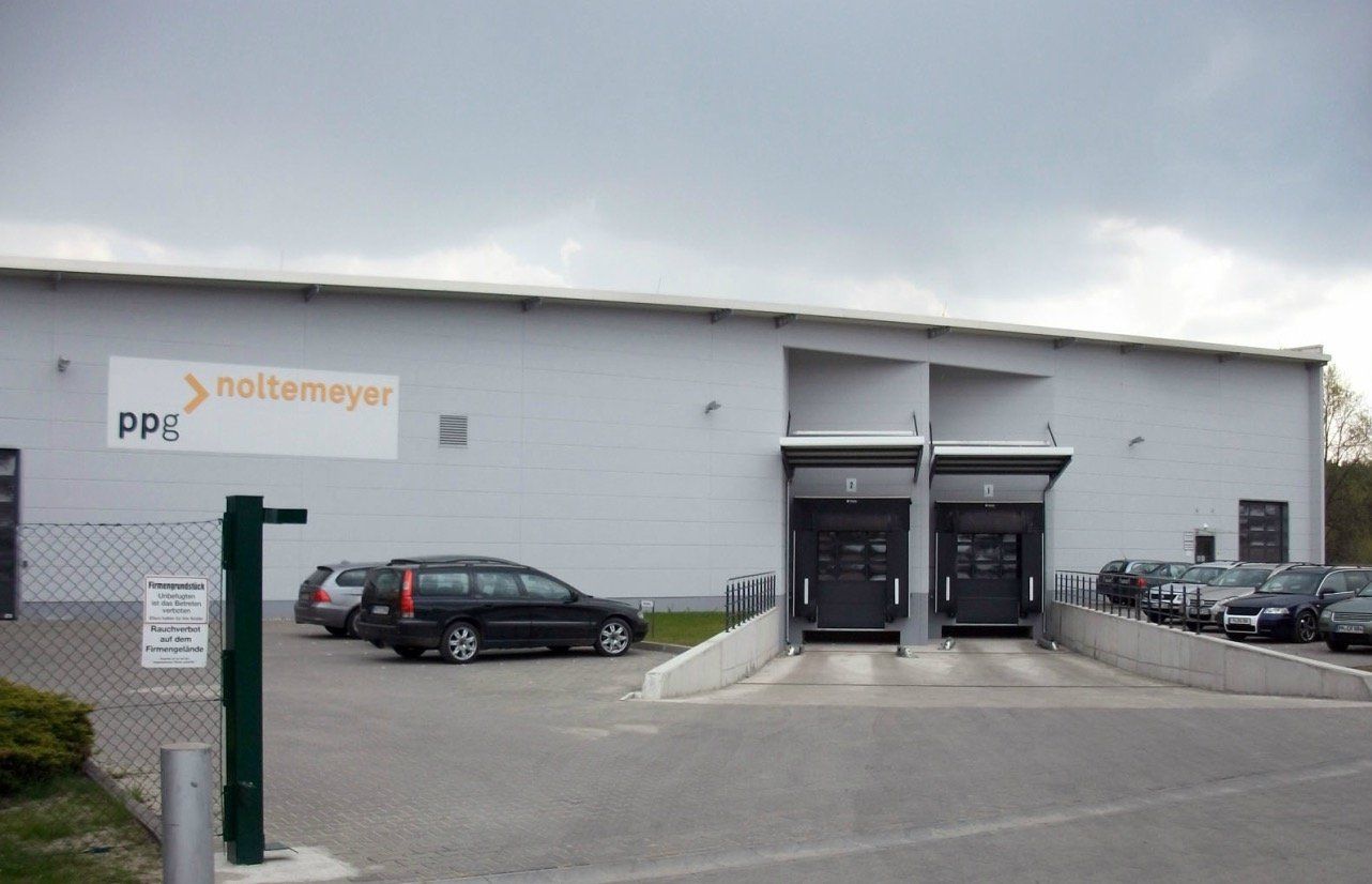 A large white building with cars parked in front of it