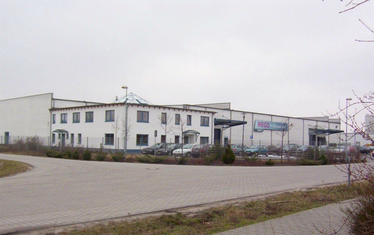 A large white building with cars parked in front of it
