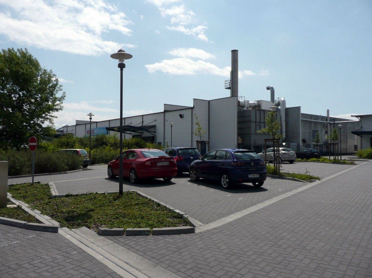 A parking lot with cars parked in front of a building.