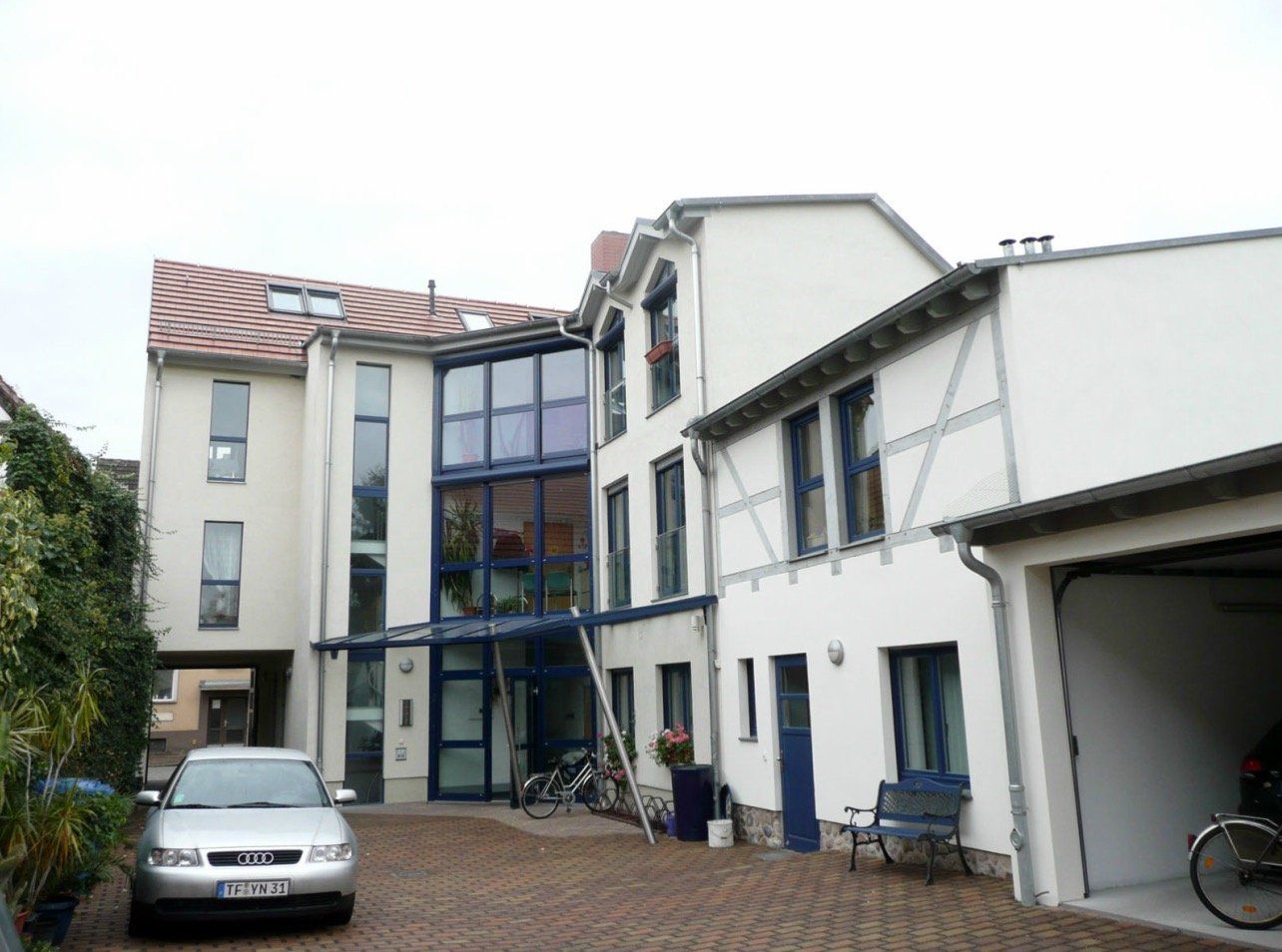 A silver car is parked in front of a building