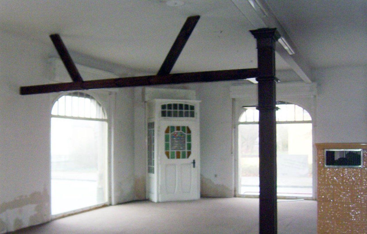 An empty room with arched windows and a door