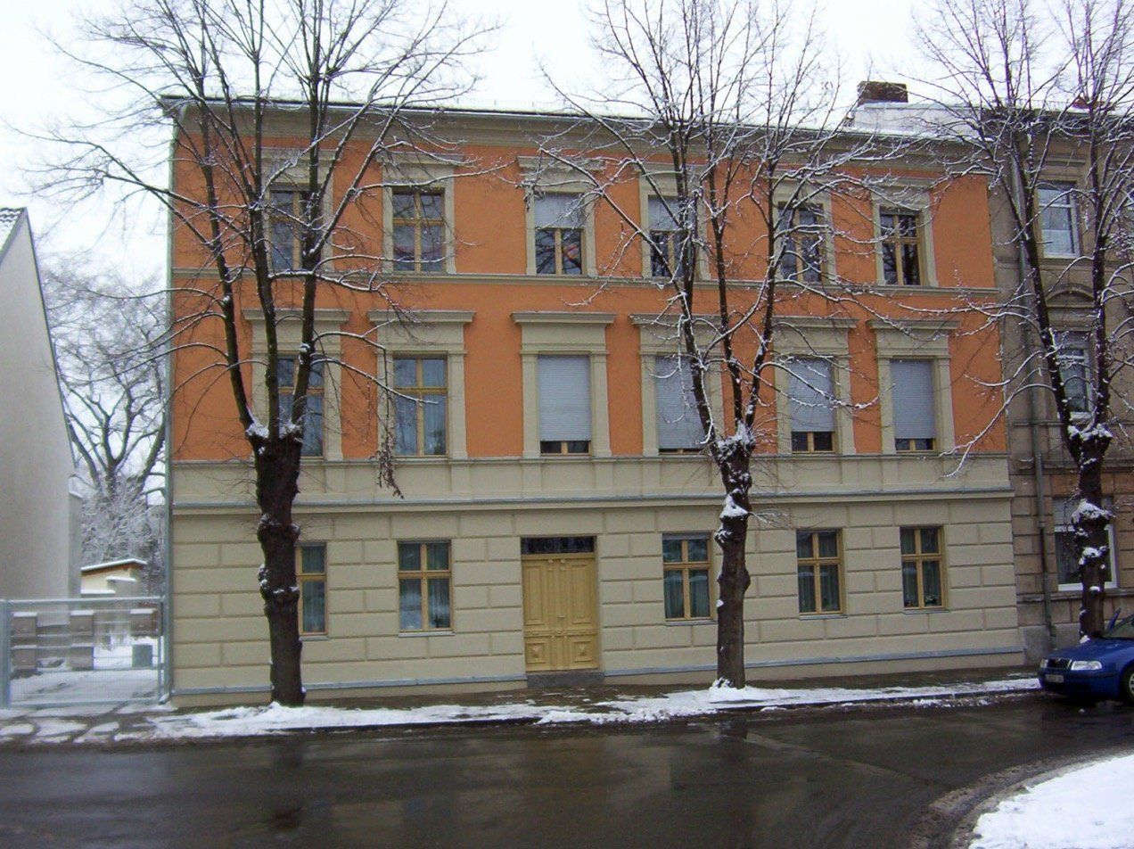 A building with a lot of windows and trees in front of it