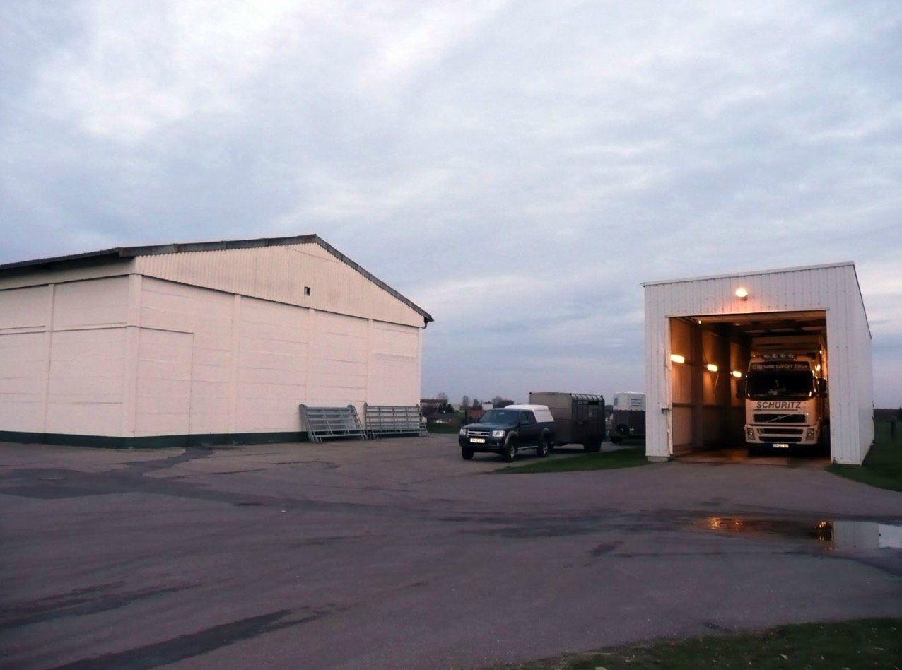 A truck is parked in a garage next to a building