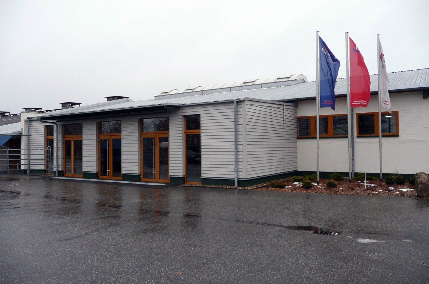 A white building with three flags in front of it