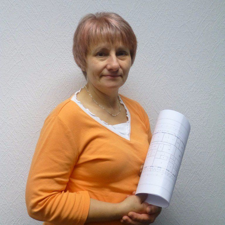 Eine Frau in einem orangefarbenen Hemd hält ein Stück Papier