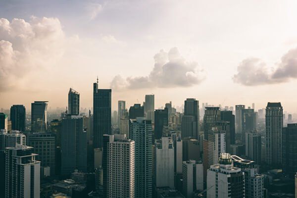 An aerial view of a city skyline with a cloudy sky in the background.