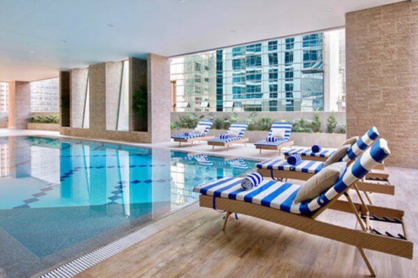 A large indoor swimming pool with lounge chairs around it